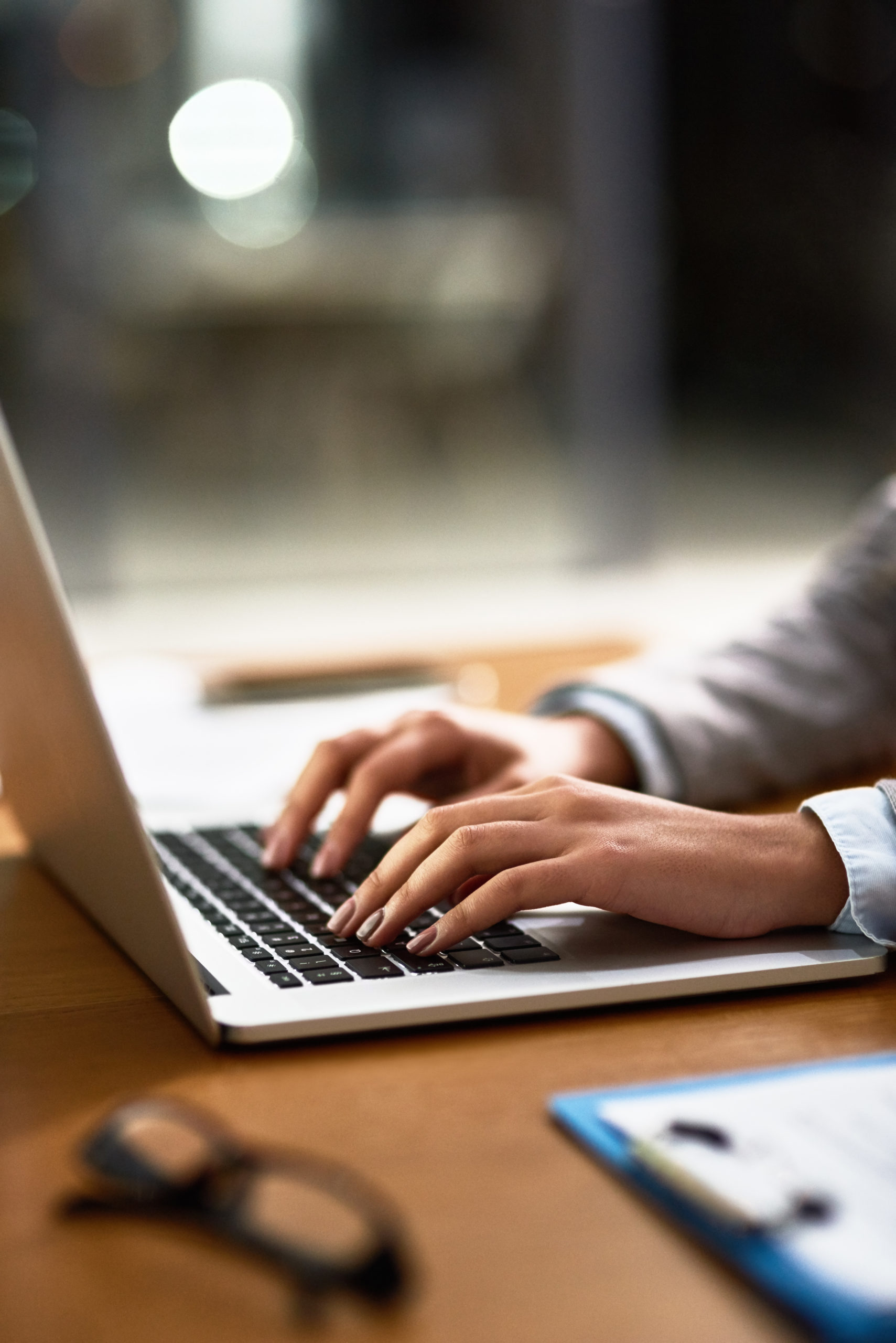 Cropped shot of a businesswoman using a laptop at her desk in a modern office